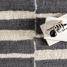 a zebra figurine sitting on top of a white and black plate next to a knife