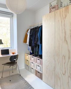 an image of a closet with clothes hanging on the door and shelves in front of it