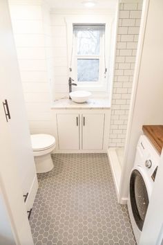 a bathroom with a washer and dryer next to a window on the wall