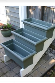 three planters sitting on the side of a house