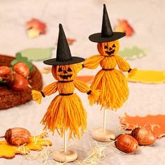 two scarecrows with black hats and tassels on their heads are standing next to nuts