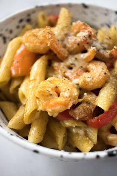 a white bowl filled with pasta and shrimp