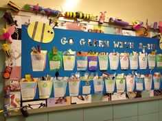 a bulletin board with lots of paper cups hanging on it's sides and the words go green with 2012