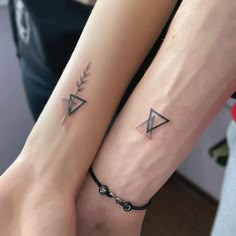 two people with matching tattoos on their arm and wrist, both holding each other's hands