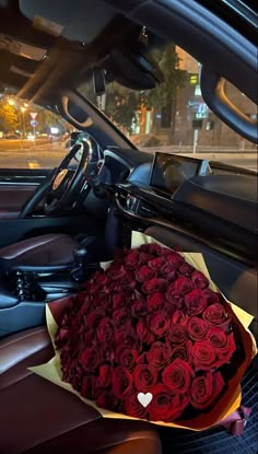 a bouquet of red roses in the back seat of a car