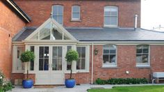 a brick house with two large blue planters in front