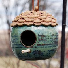 a bird house hanging from a metal pole