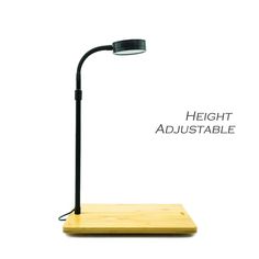 a desk lamp that is sitting on top of a wooden platform with the words height adjustable