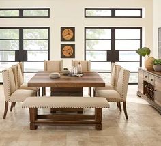 a dining room table and chairs in front of large windows