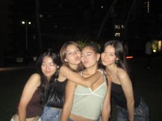 four girls are posing for the camera at night