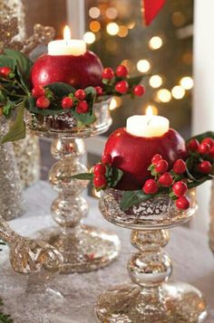 two glass vases filled with apples and candles