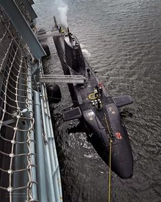 an aircraft is on the water next to a boat in the water and roped off