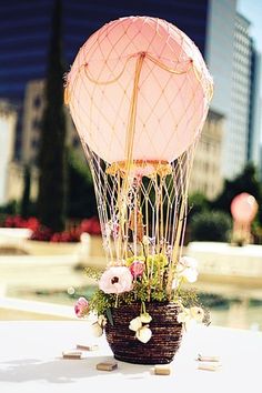 a vase with flowers in it sitting on the ground next to a street sign and buildings