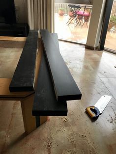 a long bench sitting on top of a hard wood floor next to a sliding glass door