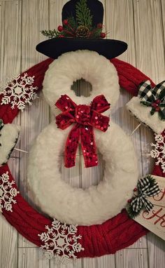 a snowman wreath with red and white decorations