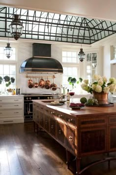 a large kitchen with an island in the middle and lots of pots on top of it