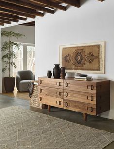 a living room with a large rug on the floor and a wooden dresser in front of it