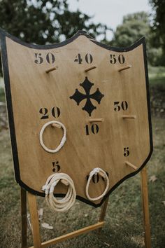 an old wooden board with numbers and rings on it in the middle of a field