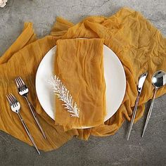 a white plate topped with a piece of cake next to two forks and spoons