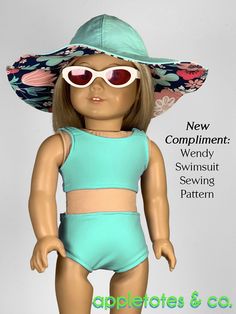 a doll wearing a blue swimsuit and sunhat with pink sunglasses on her head