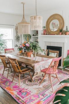 the dining room table is surrounded by pink chairs and potted plants on top of an area rug