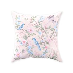 a pink pillow with blue birds and flowers on the front, sitting on a white background