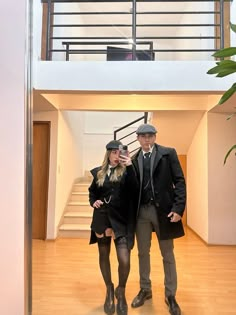 a man and woman standing in front of a staircase