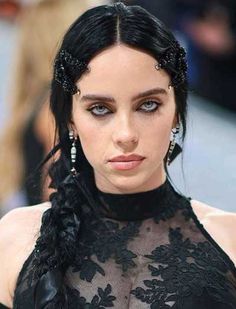 a close up of a person wearing a black dress with braids on her hair