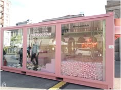 a large pink box sitting on the side of a road