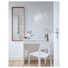 a white desk with a mirror and chair in front of it on top of a hard wood floor