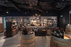 the inside of a wine shop with several wooden barrels