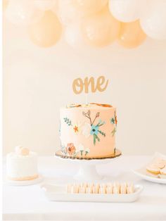 a cake sitting on top of a table next to a plate with cookies and marshmallows