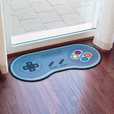 a nintendo wii game controller mat on the floor in front of a door with an open window