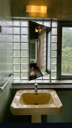 a bathroom sink sitting under a mirror next to a window