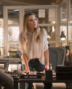 a woman standing at a desk in an office