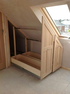 an attic bedroom with wooden furniture and skylight in the roof area, on top of a sloped building