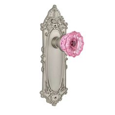 an ornate door handle with a pink flower on it