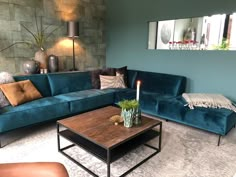 a living room filled with furniture and a coffee table in front of a blue couch