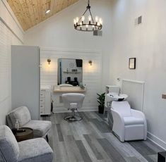 a salon with chairs and lights in the ceiling, white walls and wood flooring