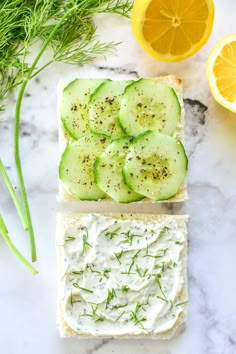 cucumber and dill spread on slices of bread with lemons next to them