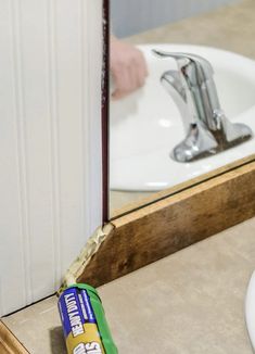 a bathroom sink with a toothbrush next to it and a mirror in the background