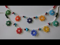 the beaded necklace is decorated with colorful beads and flower decorations on white stringing