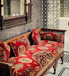 a red couch sitting in front of a mirror