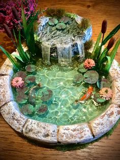 a small pond with fish and flowers in it