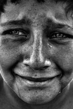 a black and white photo of a man with tears on his face