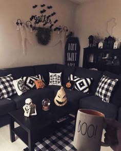 a living room filled with black furniture and halloween decorations on the wall above it's coffee table