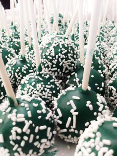 green cake pops with white sprinkles on them