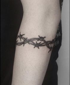 a man's arm with barbed wire tattoo on the left side of his body