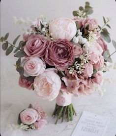 a bridal bouquet with pink flowers and greenery