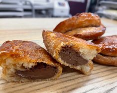 three pastries sitting on top of a wooden cutting board